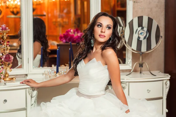Novia en vestido de novia blanco cerca del espejo —  Fotos de Stock