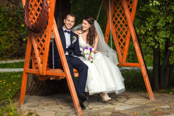 Novia y novio felices en la boda en el banco — Foto de Stock