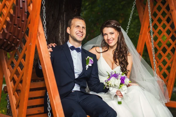 Novia y novio felices en la boda en el banco — Foto de Stock