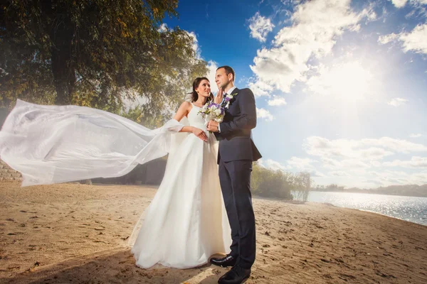 Boldog menyasszony és a vőlegény az esküvő a tengerparton folyó közelében — Stock Fotó