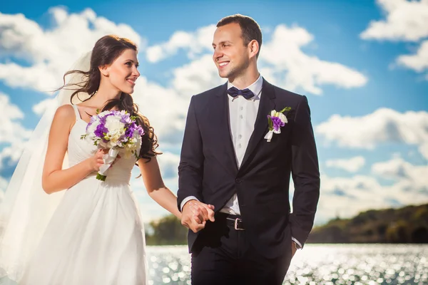 Šťastné nevěsty a ženicha na svatbu na pláži poblíž řeky — Stock fotografie