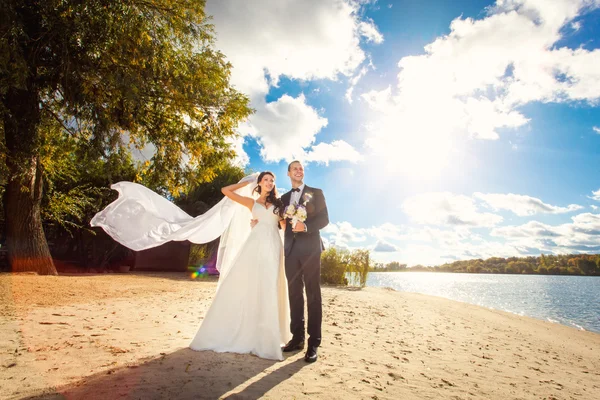 Novia feliz y novio en la boda en la playa cerca del río — Foto de Stock