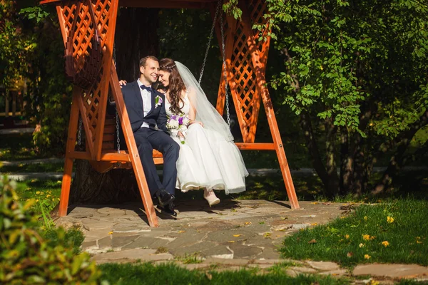 Šťastné nevěsty a ženicha na svatbě na lavičce — Stock fotografie