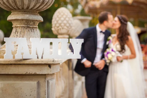 Happy bride and groom at wedding with sign Family — Stock Photo, Image