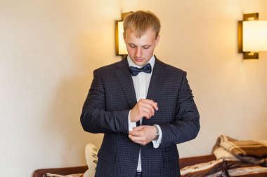 Düğün elbise giymiş ve kelepçeleri kadar düğmelerini damat