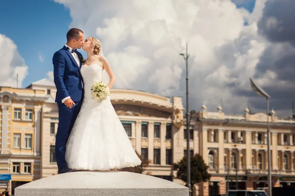 Csók a menyasszony és a vőlegény épület előtt — Stock Fotó