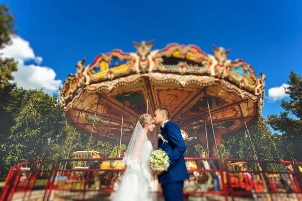 Koppel in park in de buurt van ouderwetse carrousel — Stockfoto