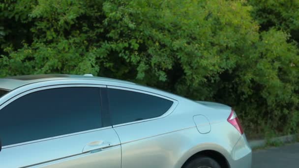 Jovem macho se aproximando e entrando carro de passageiros cinza — Vídeo de Stock