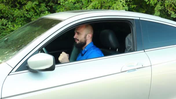 Young man with beard dancing and singing in his passenger car — Stock Video