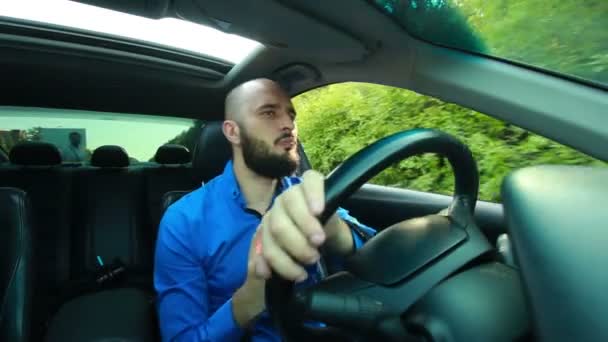 Joven con barba canta y baila mientras conduce su coche — Vídeos de Stock