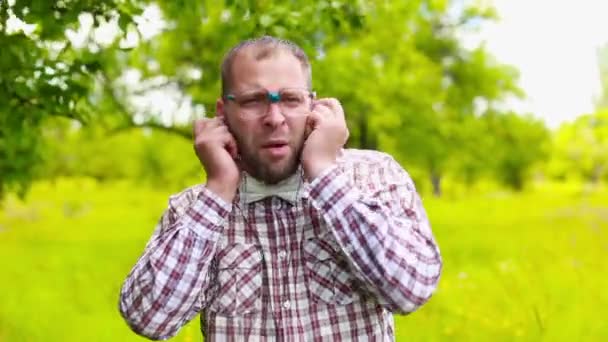 Homem de óculos ouvindo música com fones de ouvido e cantando — Vídeo de Stock