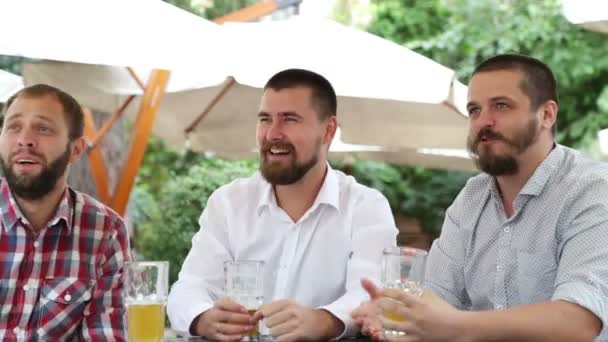 Los hombres con barba en la cafetería al aire libre viendo partido y mirando muy feliz — Vídeos de Stock