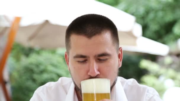 Jeune homme avec barbe clin d'oeil et boire de la bière légère mousseuse — Video