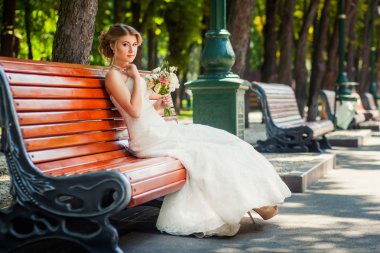 Park ahşap bank üzerinde mutlu gelin