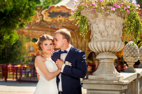 Mariée touchante près du carrousel dans le parc — Photo