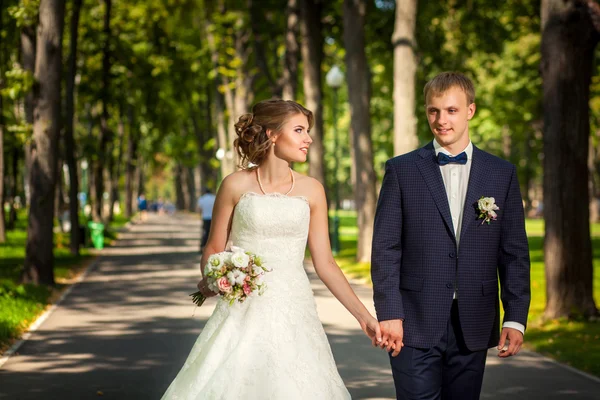 Sposo e sposo in parco lungo la passerella — Foto Stock