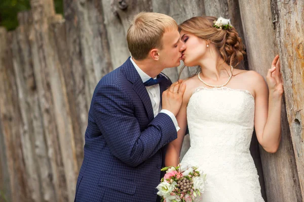 Beijar casal perto de cerca rústica de madeira — Fotografia de Stock