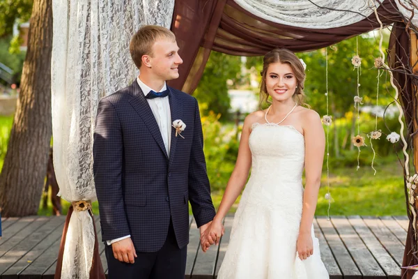 Casal de casamento sob arco de casamento no verão — Fotografia de Stock