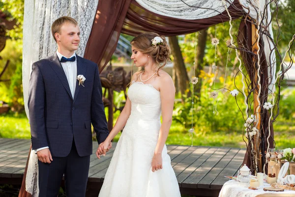 Наречений і наречений під декоративною весільною аркою — стокове фото