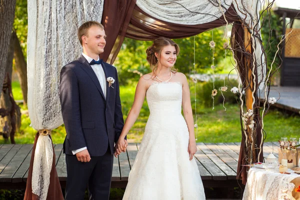 Brilho e noiva sob arco de casamento decorativo — Fotografia de Stock