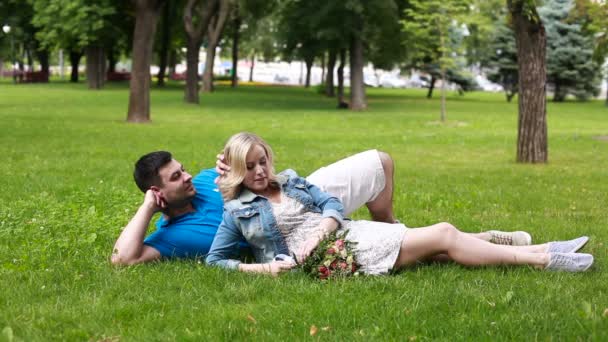 Masculino acariciando seu feminino 's cabelo e segurando ela no verão parque — Vídeo de Stock