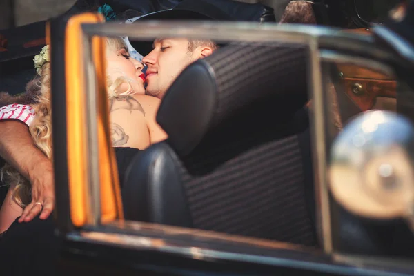 Feliz casal beijando no luxo carro preto — Fotografia de Stock