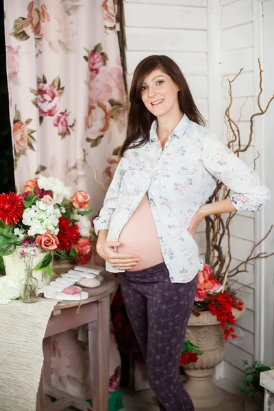 Przyszłej matki w pobliżu tabela z kwiatami — Zdjęcie stockowe