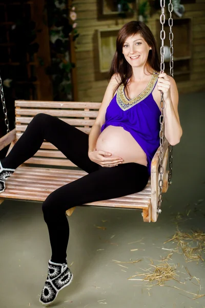 Przyszłej matki siedzi na swing — Zdjęcie stockowe
