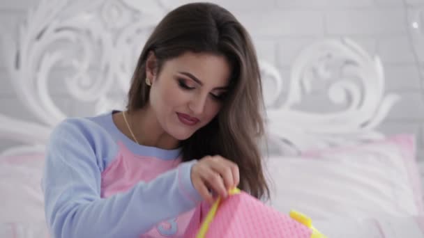 Улыбающаяся женщина смотрит на свои подарки — стоковое видео