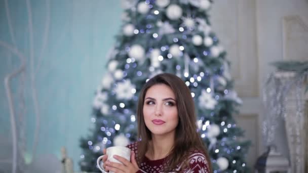 Hermosa modelo con copa cerca del árbol de Navidad — Vídeo de stock