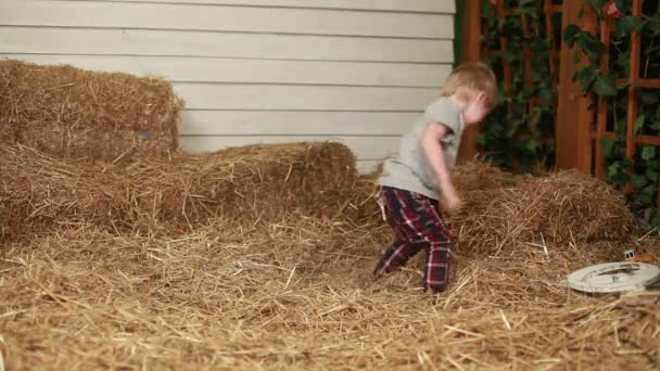 Happy boy throwing the straw indoors — Stock Video