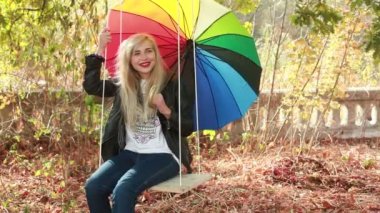 Kız parkta sallanan şemsiye ile