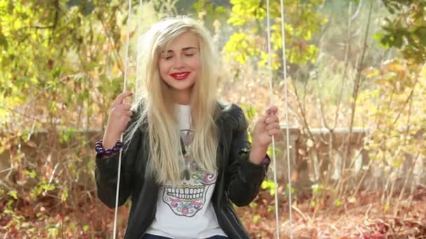 Aantrekkelijk meisje swingend in park — Stockvideo