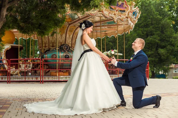Noivo em seu joelho na frente da noiva — Fotografia de Stock