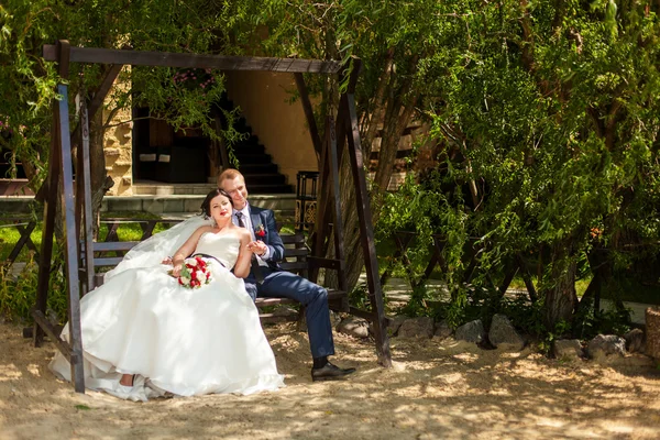 Bröllopsparet på bänk i parken — Stockfoto