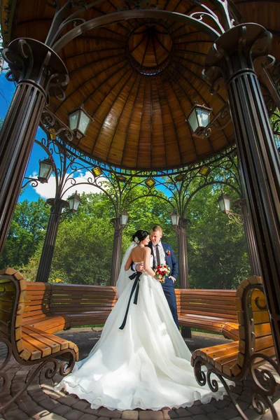 Casamento casal no pavilhão com bancos — Fotografia de Stock