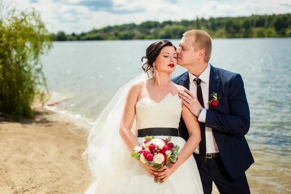 Наречена цілує наречену біля річки — стокове фото