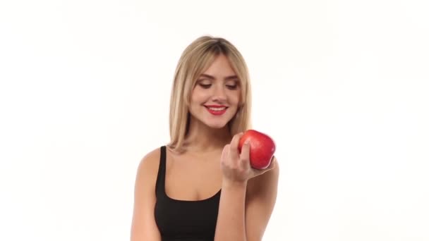 Beauty woman eating fresh and juicy apple at white background — Stock Video