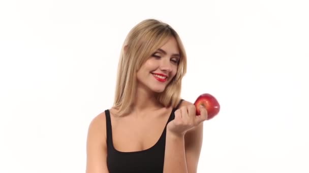 Beauty woman eating fresh and juicy apple at white background — Stock Video