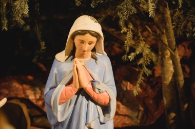 Meryem Ana heykelinin yakın çekimi, İsa 'nın doğumu sahnesinde ellerini birbirine kenetleyerek dua ediyor.