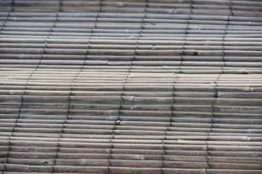 Bambu çitlerin ayrıntıları, bir pergola üzerinde dalgalanıyor, yukarıdan görülüyor.