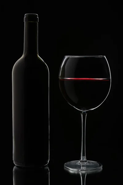 Glas rött vin och flaska — Stockfoto