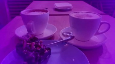 Bir fincan cappuccino ve tatlı, parlak bir arka plan.