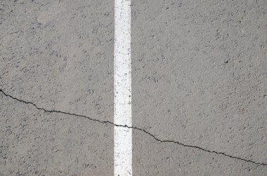 Beyaz kırık asfalt üzerinde şerit