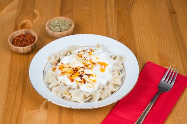 Kırmızı biber, tereyağı, sos, yoğurt ve nane ile plaka üzerinde Türk mantı (mantı)