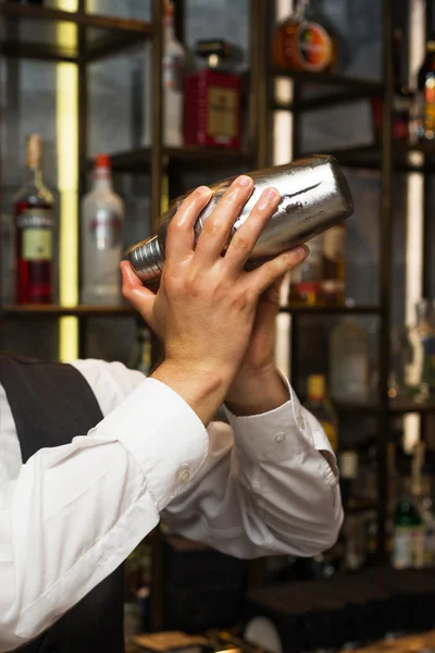 Barman no trabalho, a preparar cocktails. Agitar coquetel shaker . — Fotografia de Stock