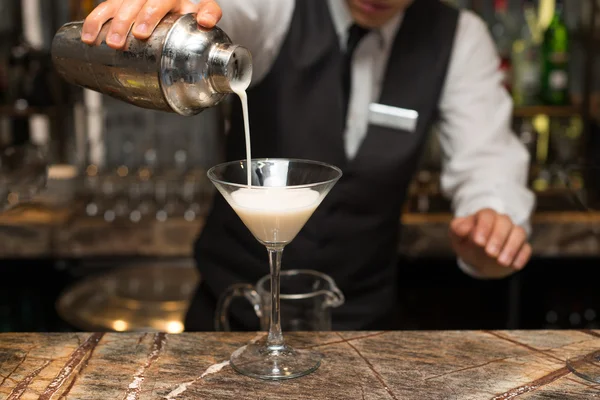 Barman no trabalho, a preparar cocktails. derramando pina colada para copo de coquetel. conceito sobre serviço e bebidas . — Fotografia de Stock