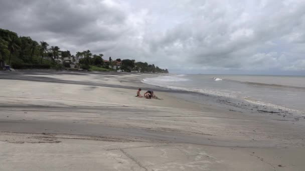 太平洋の端にある砂浜で砂の城を作る子供たちとそのお母さん — ストック動画
