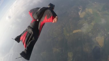 Wingsuit skydiving over clouds clipart