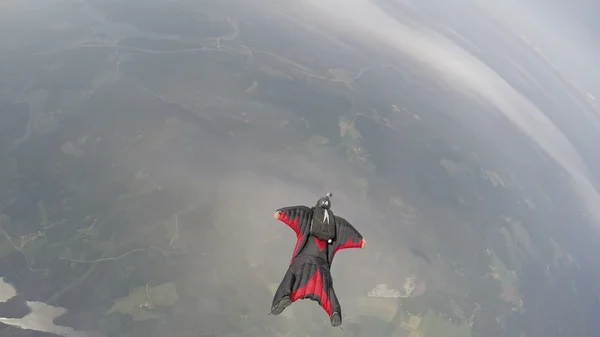 Wingsuit parachutespringen boven wolken — Stockfoto